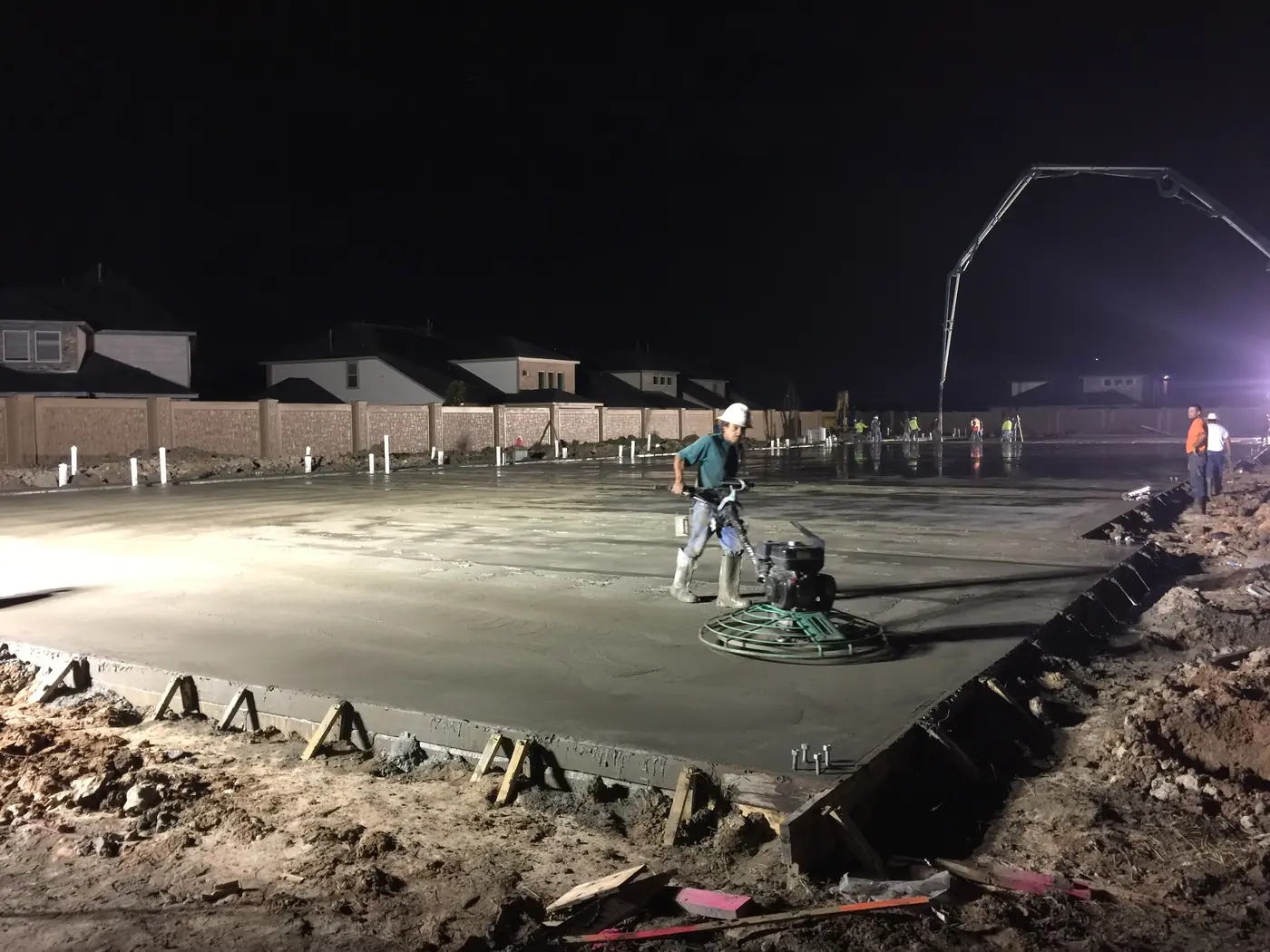 Concrete crew placing and finishing a large slab at night
