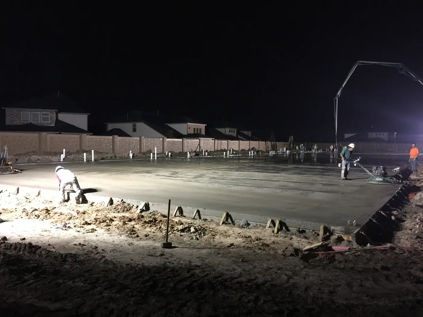 Wide view of nighttime concrete slab finishing operations