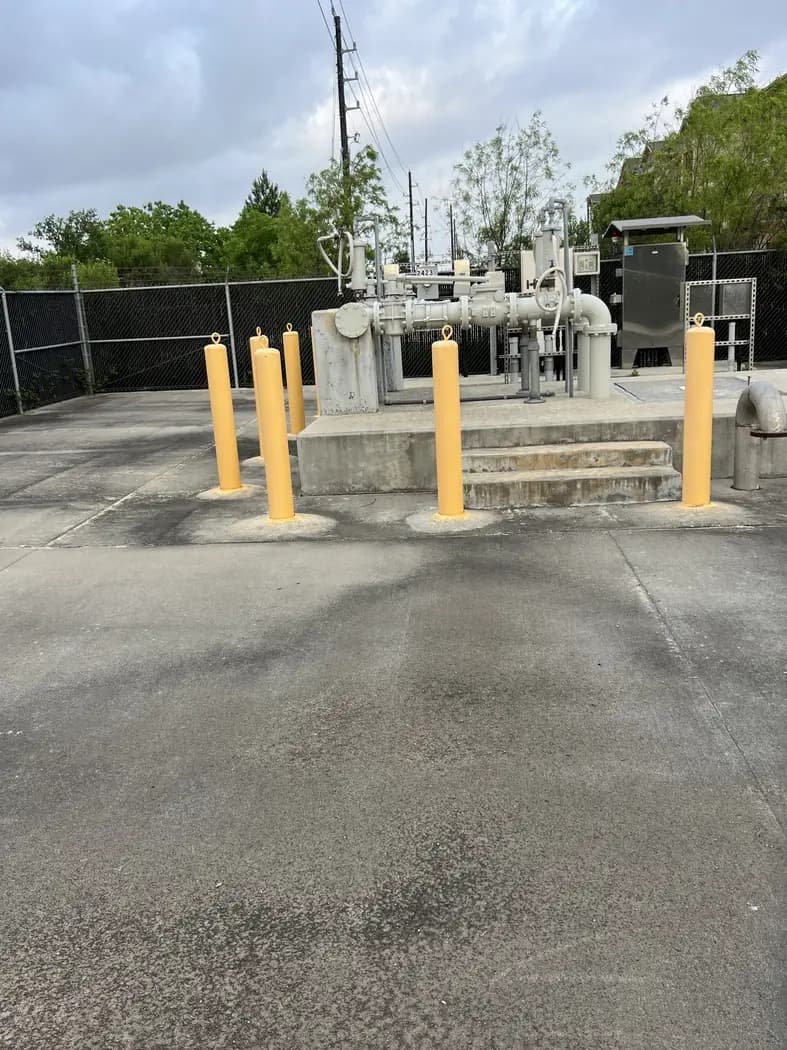 Commercial utility equipment protected by bollards and fencing