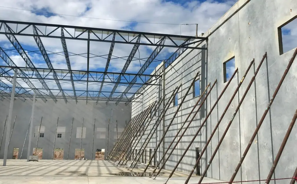Steel roof framing spanning between tilt-wall concrete panels