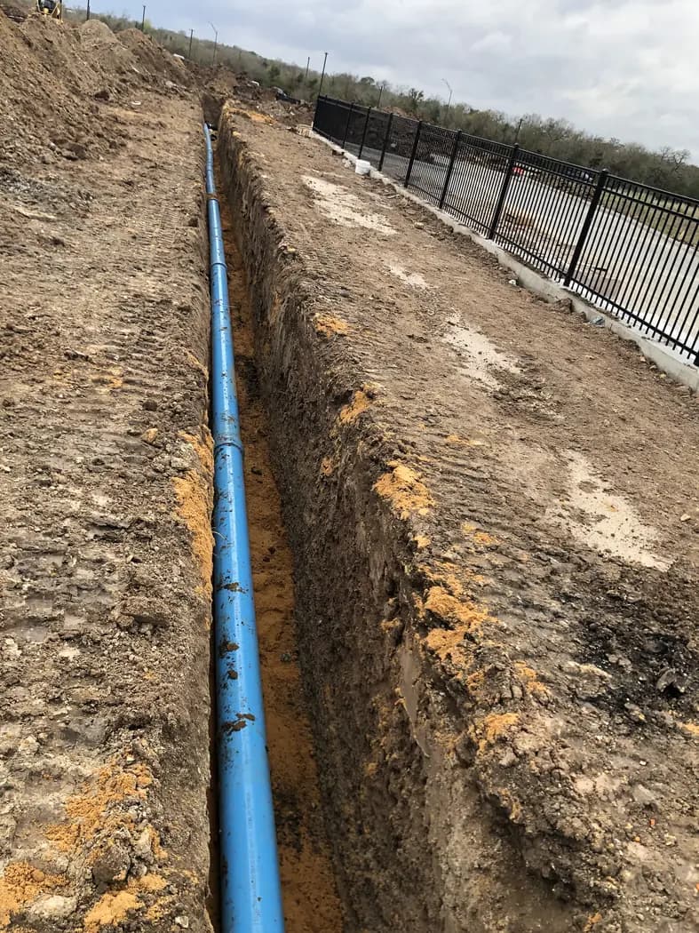 Blue underground utility line installed in a long site trench