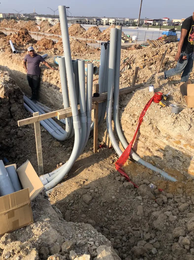 Utility conduits and service stubs positioned within an excavation