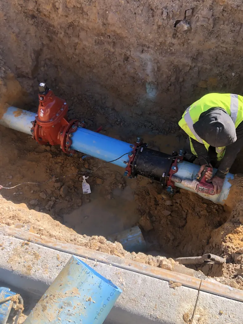 Field crew completing an underground utility connection in a trench