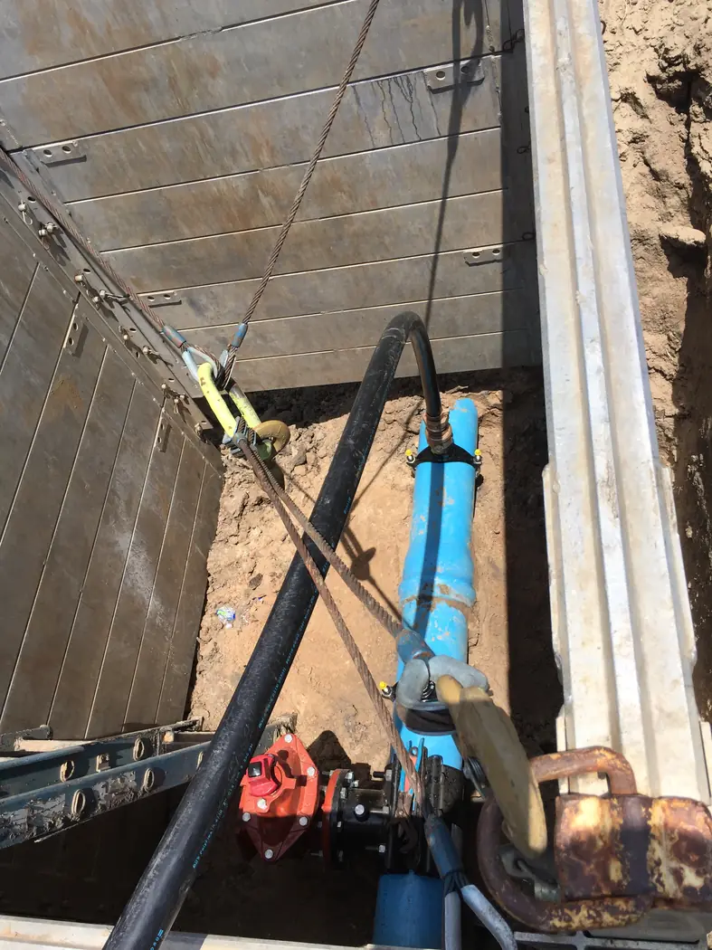 Vertical utility work inside a concrete wall enclosure