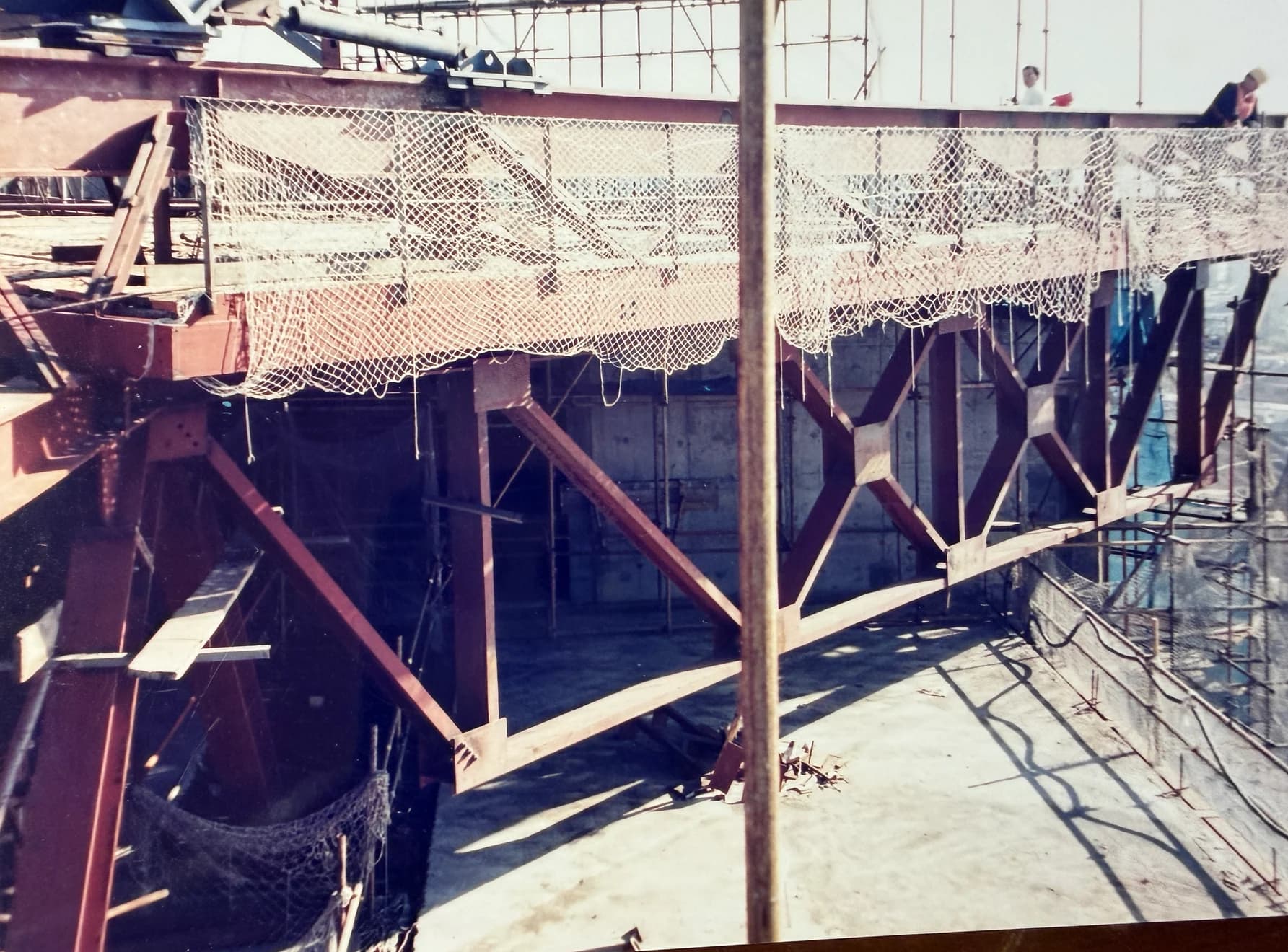 Cross-braced steel roof support framing and temporary safety netting during hotel construction