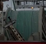 Coiled flexible pipe positioned within specialized handling equipment
