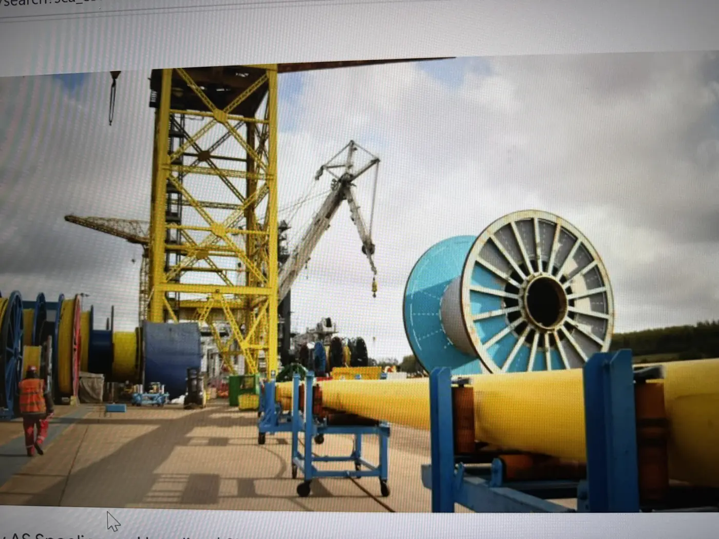 Large pipe reels and lifting equipment inside an industrial facility