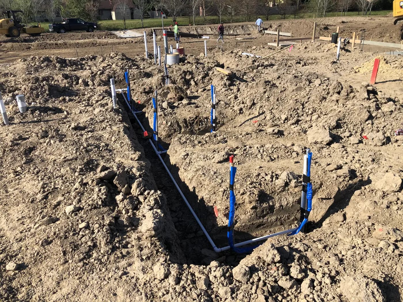 Field crew installing a long process pipe within an excavated corridor