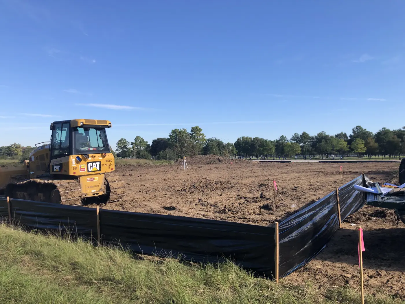 Bulldozer working beside installed perimeter erosion-control fencing
