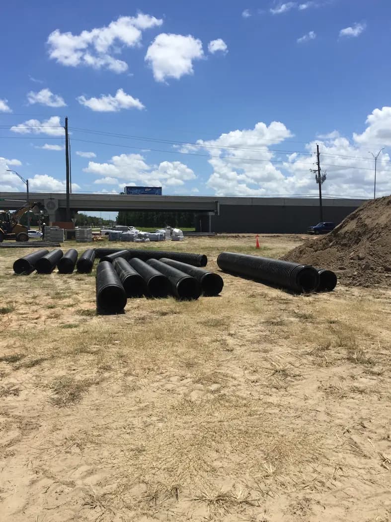 Underground utility pipe staged across a prepared development site